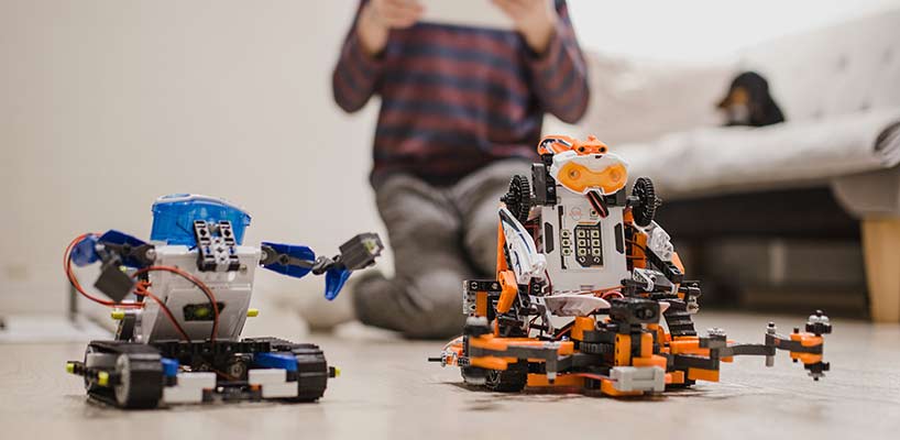 03 IOTA Boy Using Tablet And Robots